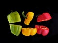 Red, yellow and green peppers, levitation on a black background Royalty Free Stock Photo