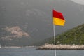 A red and yellow life saving flag by the sea Royalty Free Stock Photo