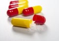 red and yellow open pills on white background Royalty Free Stock Photo