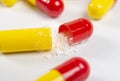 red and yellow open pills on white background, health and nature, top view, copy space Royalty Free Stock Photo