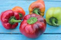 Red, yellow and orange bell peppers on light blue wooden background. Fresh summer or autumn vegetables harvest Royalty Free Stock Photo