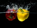 Red and Yellow Paprika Splash in Water Isolated on black Background Royalty Free Stock Photo