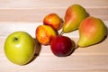 Red-yellow peaches, yellow pears, a green apple lie on the table Royalty Free Stock Photo