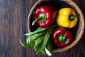 Red and Yellow Pepper with Green Runner Beans in Wooden Basket. Royalty Free Stock Photo