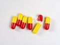 red and yellow pills with open pill on white background, health and nature, top view, copy space Royalty Free Stock Photo