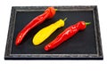 Red and yellow pointed chili on slate blackboard