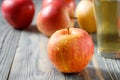 Red yellow ripe apple Royal Gala with water drops closeup on blurred background with apples and glass of cider or sparkling juice Royalty Free Stock Photo