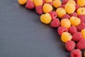 Red and yellow ripe natural raspberries on black stone background. Close-up view. Royalty Free Stock Photo