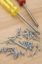 Red and Yellow Screwdrivers with Screws on Wood Royalty Free Stock Photo