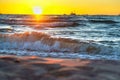 Red yellow sunset on the sea shore, in the surf of the waves of the Baltic sea, a magnificent sunrise