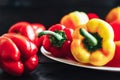 Red and yellow sweet bell peppers on wite plate close up Royalty Free Stock Photo