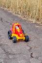 Red and yellow toy tractor with toy cow as tractor driver on a road Royalty Free Stock Photo