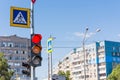 Red and yellow traffic light at the intersection of streets. A sign of a pedestrian crossing. Royalty Free Stock Photo