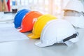 Red Yellow White and blue Safety hard hat on the blueprint with Royalty Free Stock Photo
