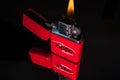 Red zippo lighter with reflection on shiny black background