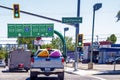 Pickup truck with kayaks and camper trailer stop at intersection with highway signs by carwash and Royalty Free Stock Photo