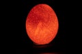 A reddish easter egg like picture of a raw egg through mobile flash light