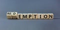 Redemption or emption symbol. Fliped a wooden cube and changed the word `emption ` to `redemption`. Beautiful grey background,