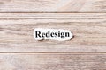 REDESIGN of the word on paper. concept. Words of REDESIGN on a wooden background