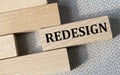 REDESIGN - word on a wooden bar on a gray background Royalty Free Stock Photo