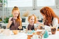 Redhead mother and two daughter mold with clay, pottery children Royalty Free Stock Photo