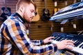 redhair ginger beard man is playing on piano in music store