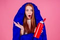 Redhair ginger woman holding red thermos and wrapped in in sleeping bag