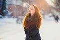 Redhair girl walks in the winter.