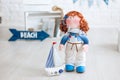 A redhair sailor doll and a ship with a sail standing on a white floor. Handmade