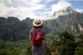 Redhair woman traveler with backpack and hat and looking at amazing mountains and forest Royalty Free Stock Photo