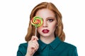 Redhaired beautiful girl in a green shirt with multi-colored round candy