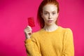 Redhaired beauty female holding credit card isolated over pink w Royalty Free Stock Photo