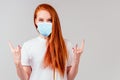 Redhaired ginger woman in white cotton t-shirt showing rocks fingers