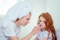 Redhaired ginger woman and foxy little girl make cucumbers clay mask