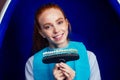 Redhaired ginger young cheerful female client sitting in dental office and getting smile whitening in egg chair Royalty Free Stock Photo