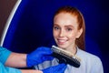 Redhaired ginger young cheerful female client sitting in dental office and getting smile whitening in egg chair Royalty Free Stock Photo