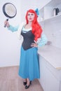 Redhaired plus size angry sad woman holding frying pan