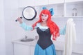 Redhaired plus size angry sad woman holding frying pan