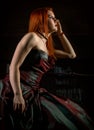 Redhaired woman in a retro dress with candles on black background Royalty Free Stock Photo