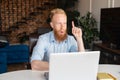 Redhead bearded man points index finger up with amazed face Royalty Free Stock Photo