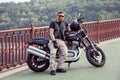 Redhead biker with beard in leather jacket and his bike.