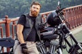 Redhead biker with beard in leather jacket and his bike.