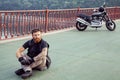 Redhead biker with beard in leather jacket and his bike.