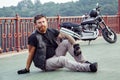 Redhead biker with beard in leather jacket and his bike. Royalty Free Stock Photo
