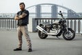 Redhead biker with beard in leather jacket standing with crossed