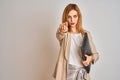 Redhead business caucasian woman holding work case over isolated background pointing with finger to the camera and to you, hand Royalty Free Stock Photo