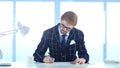 Redhead Businessman Paperwork, Writing and Working on Laptop Royalty Free Stock Photo