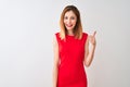 Redhead businesswoman wearing elegant red dress standing over isolated white background doing happy thumbs up gesture with hand Royalty Free Stock Photo
