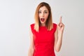 Redhead businesswoman wearing elegant red dress standing over isolated white background pointing finger up with successful idea Royalty Free Stock Photo