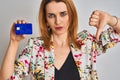 Redhead caucasian business woman holding credit card over isolated background with angry face, negative sign showing dislike with Royalty Free Stock Photo